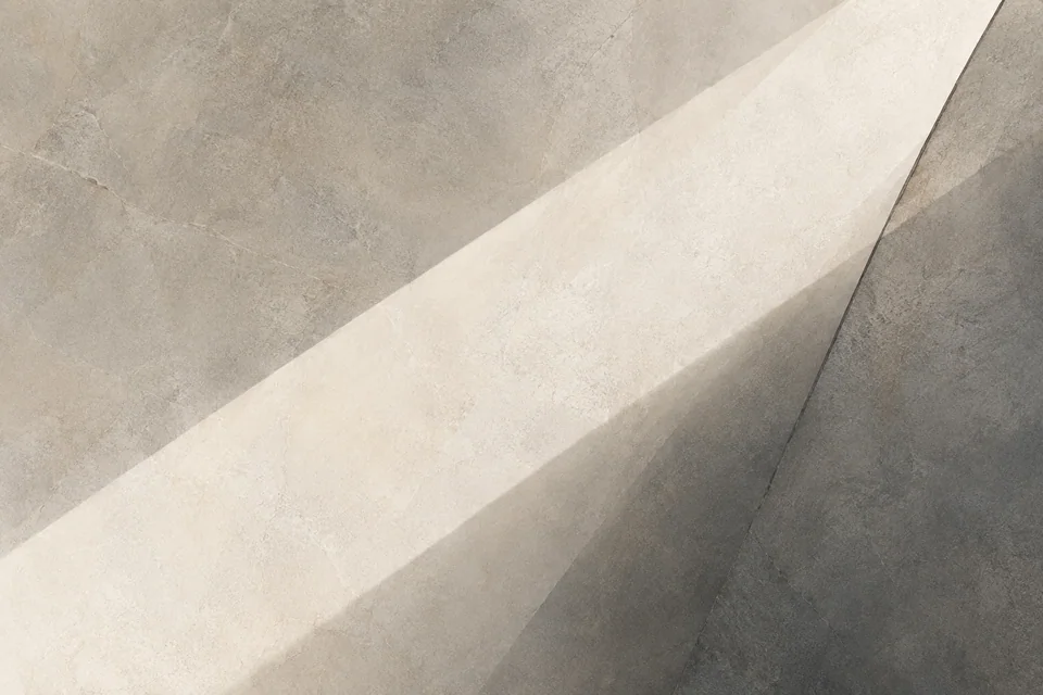 A pale diagonal band crosses softly textured stone-grey planes.