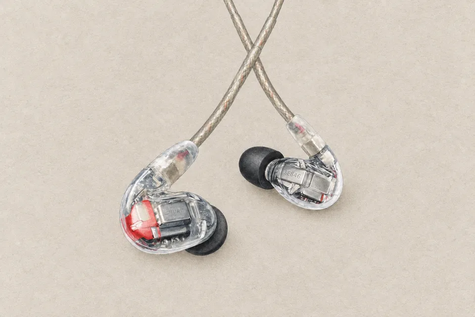 Paper-textured illustration of two transparent Shure SE846 earphones with visible internal components and black ear tips.